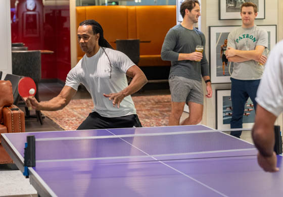 Two men playing a lively game of table tennis in the WorkHUB at the Adelaide Club, as part of a Games social night